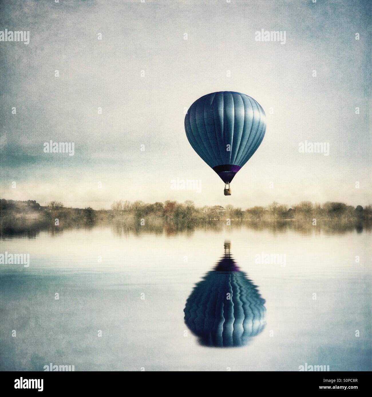 Reflection of hot air balloon in lake Stock Photo