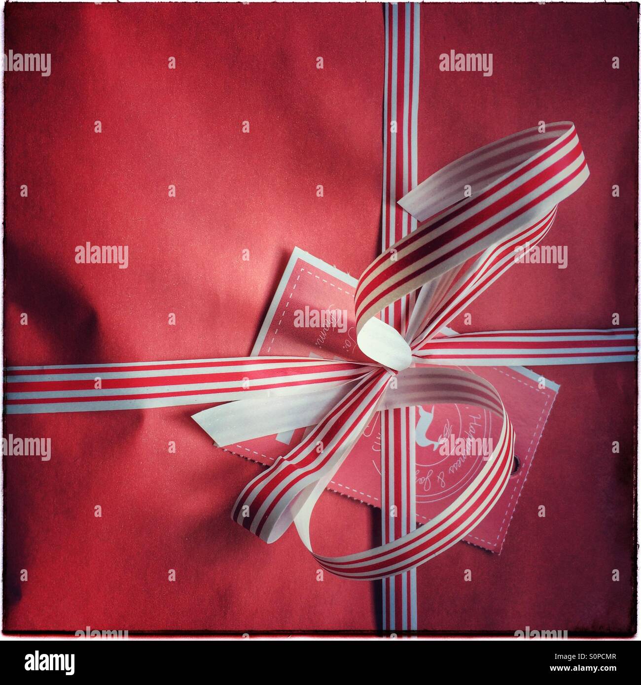 Christmas gift wrapped in red paper. - Smartphone Captured Stock Image