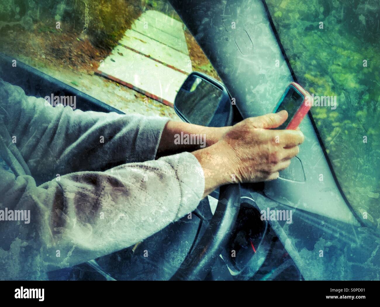 Do not text and drive. A woman's hands on a steering wheel while texting. - Smartphone Captured Stock Image