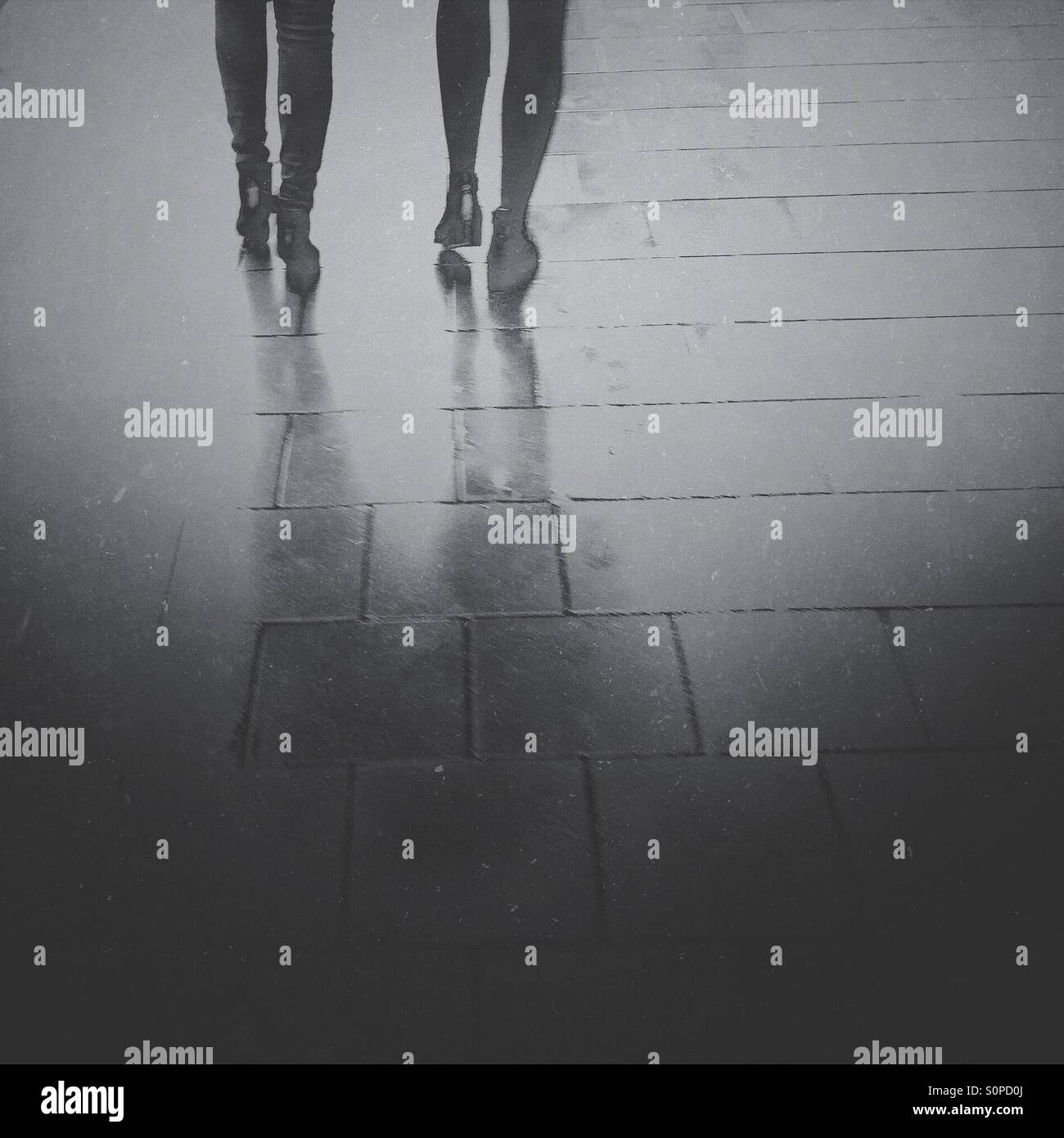 Rainy day in the city. Women feet and legs on a pavement. - Smartphone Captured Stock Image