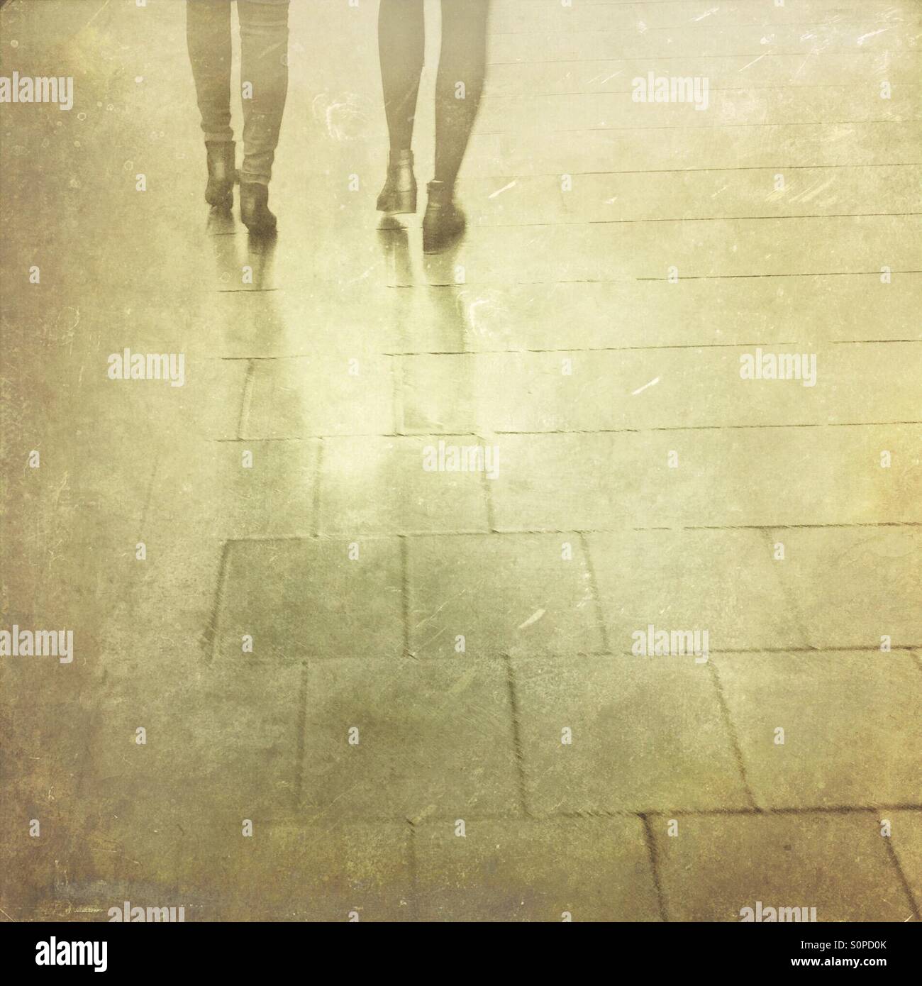 Rainy day in the city. Women feet and legs on a pavement. - Smartphone Captured Stock Image