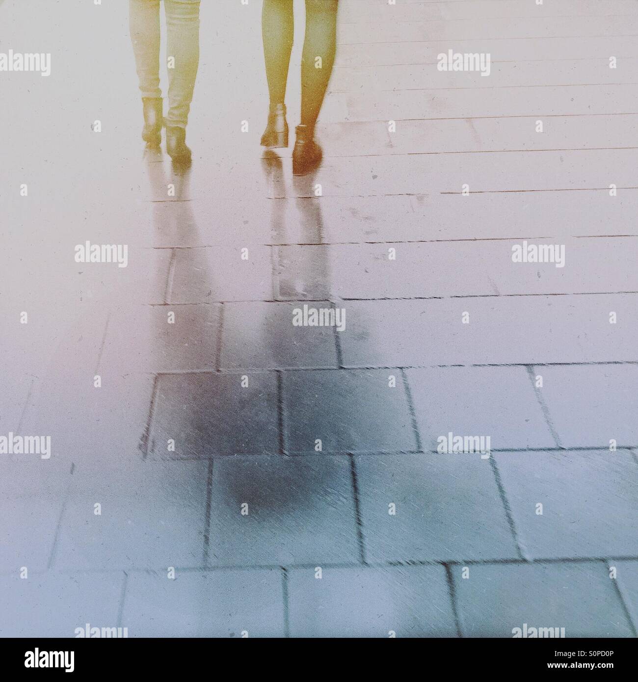 Rainy day in the city. Women feet and legs on a pavement. - Smartphone Captured Stock Image