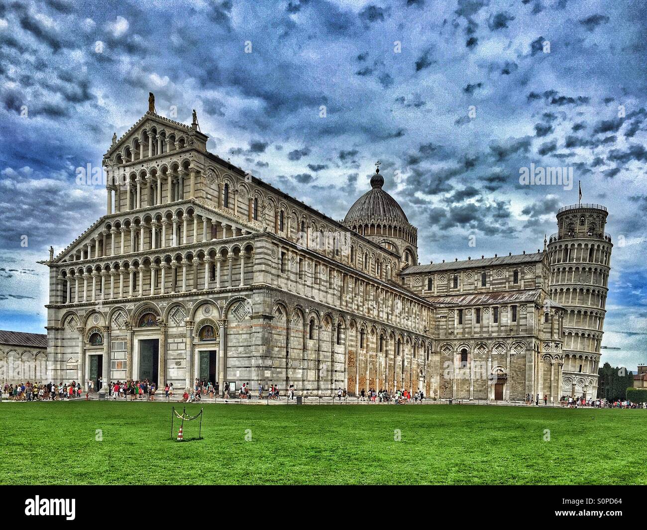 Tourists walk around Santa Maria Assunta Cathedral and the famous Leaning Tower in Pisa, Tuscany, Italy. This area is known as the Field of Miracles. Photo Credit - © COLIN HOSKINS. - Smartphone Captured Stock Image