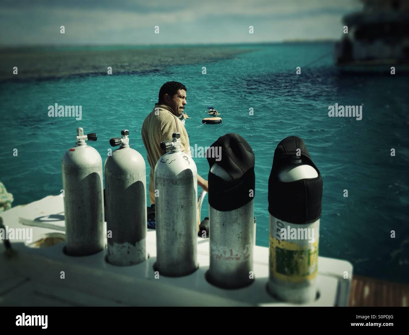 Dive boat staff behind 5 diving DIN air tanks - Smartphone Captured Stock Image