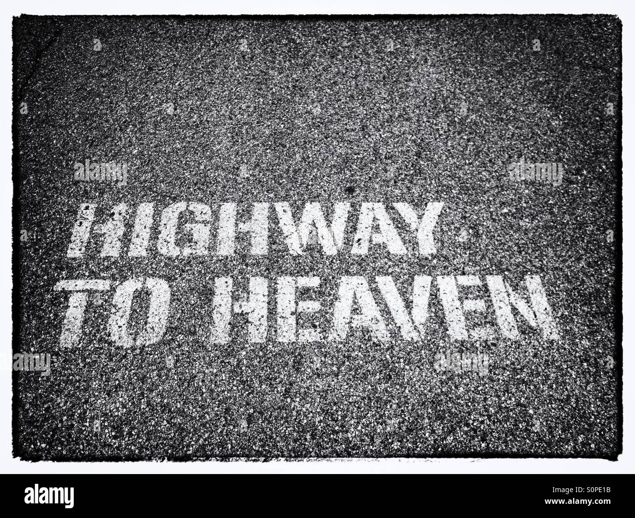 The words Highway to Heaven in white letters on asphalt road - Smartphone Captured Stock Image