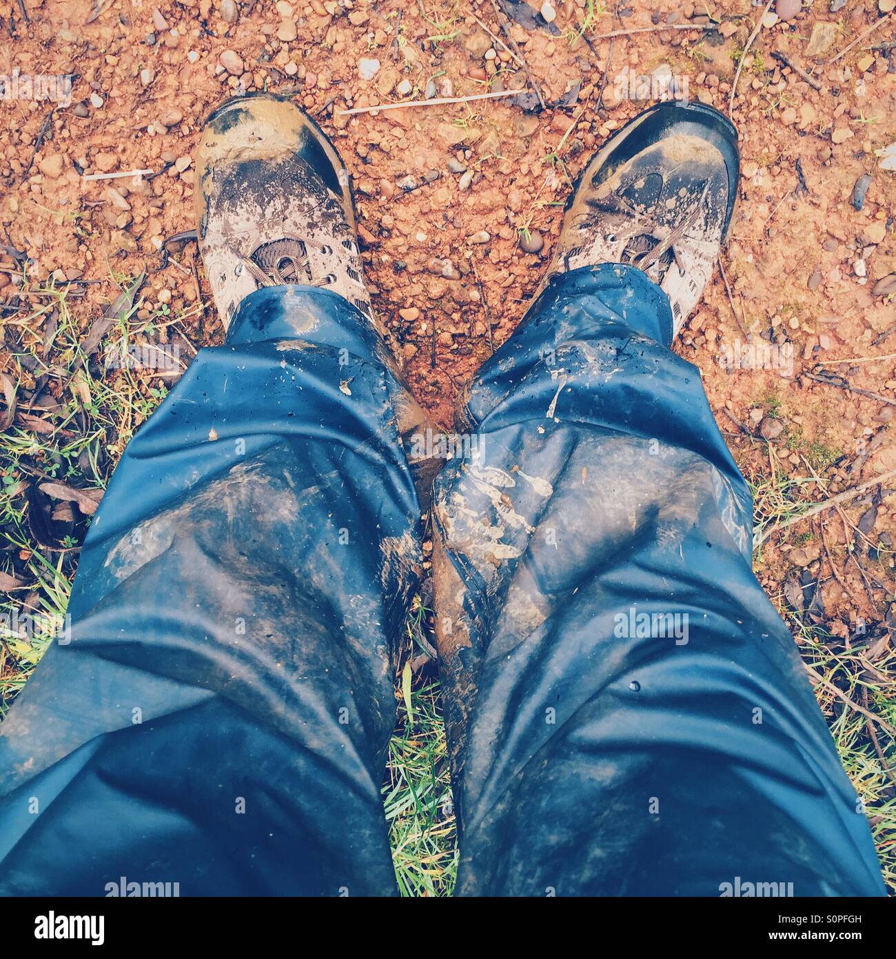Pair of legs wearing waterproof trousers and walking boots Stock Photo