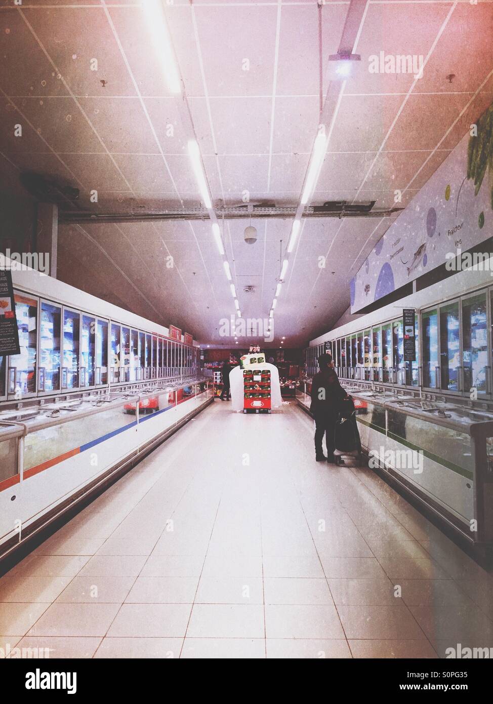 Lonely shopper in aisle of refrigerators - Smartphone Captured Stock Image
