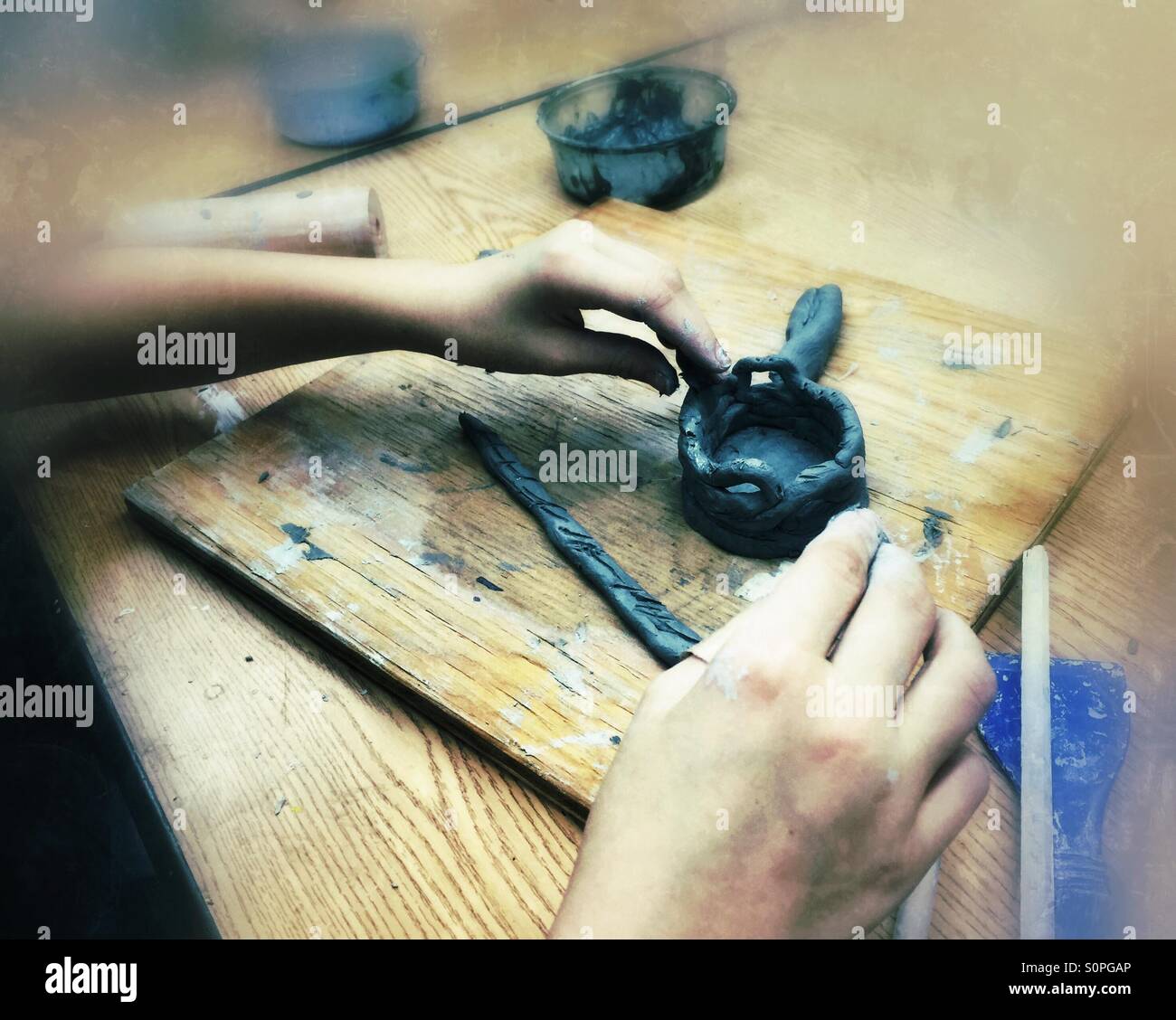 Child's hands making pinch pot out of clay - Smartphone Captured Stock Image