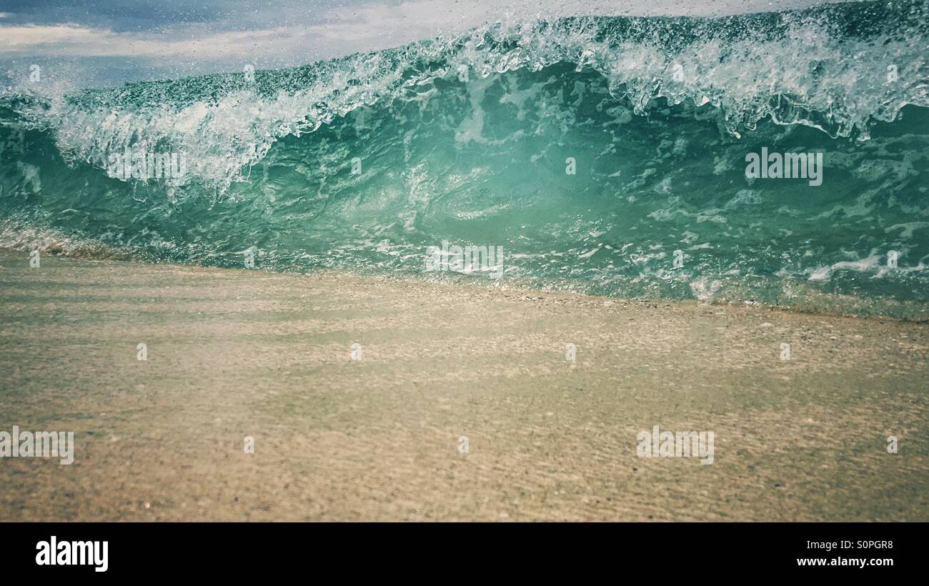 Close up of a wave about to break into a sandy beach - Smartphone Captured Stock Image