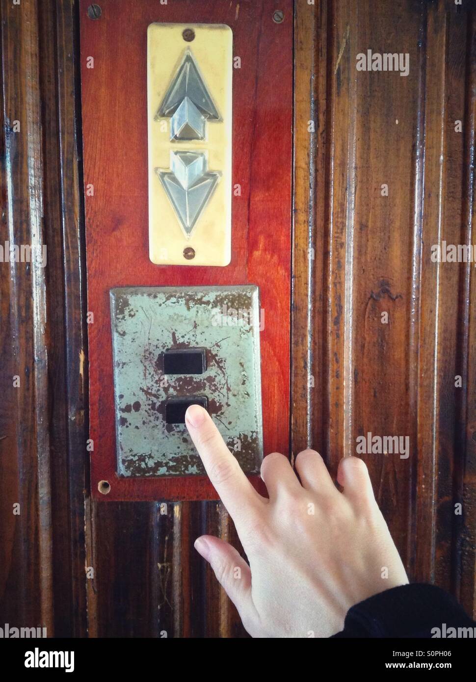 Hand pushing elevator button to go down - Smartphone Captured Stock Image