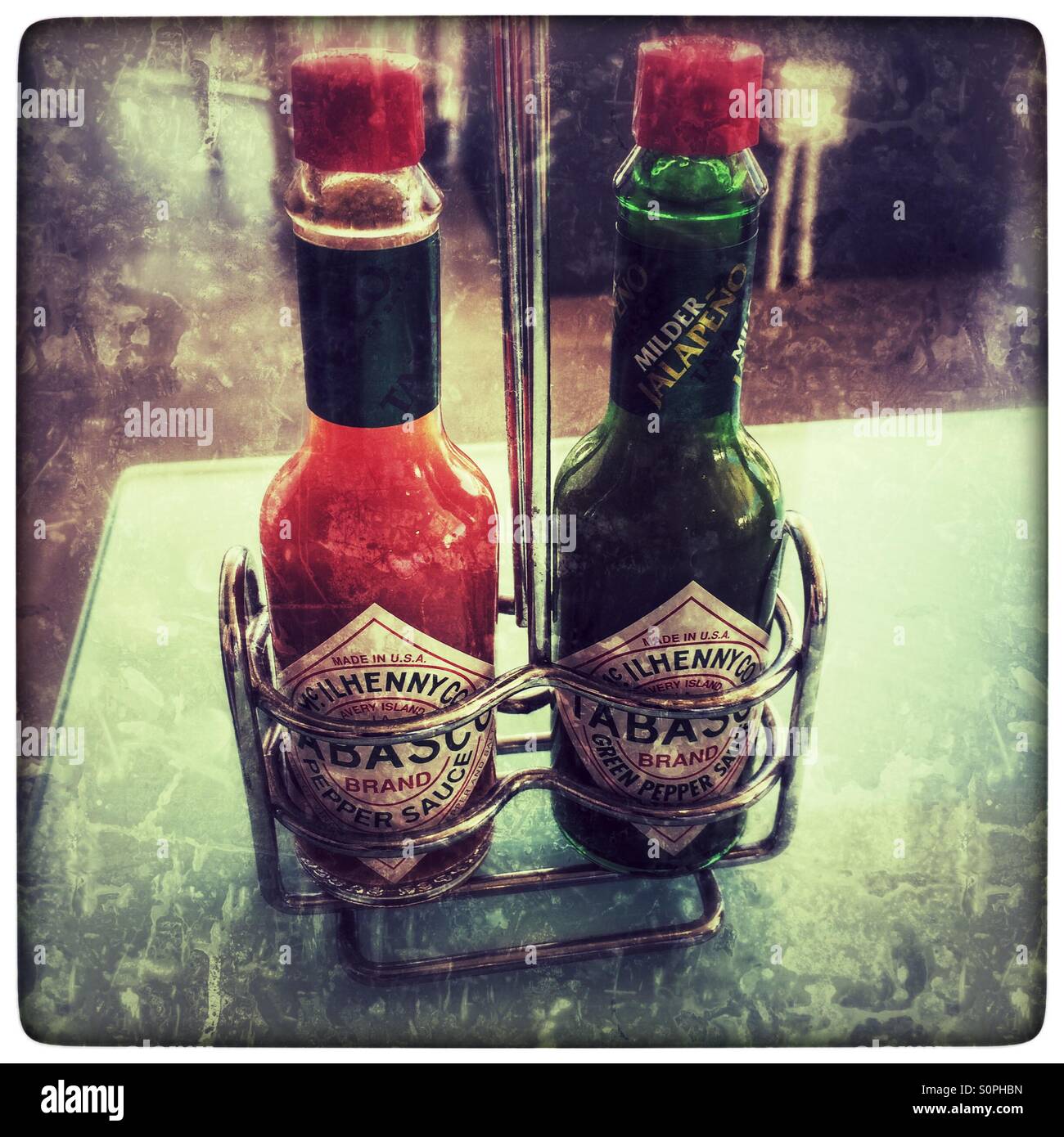 Two bottles of Tabasco sauce on restaurant table. - Smartphone Captured Stock Image