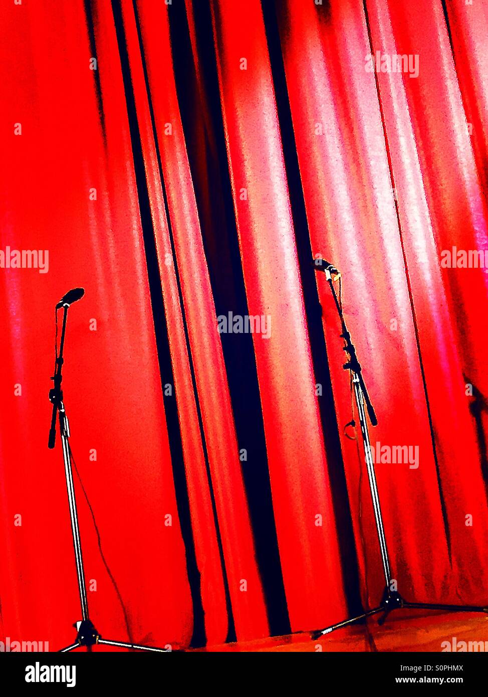 Microphone and stands in front of closed red curtain on the stage. - Smartphone Captured Stock Image