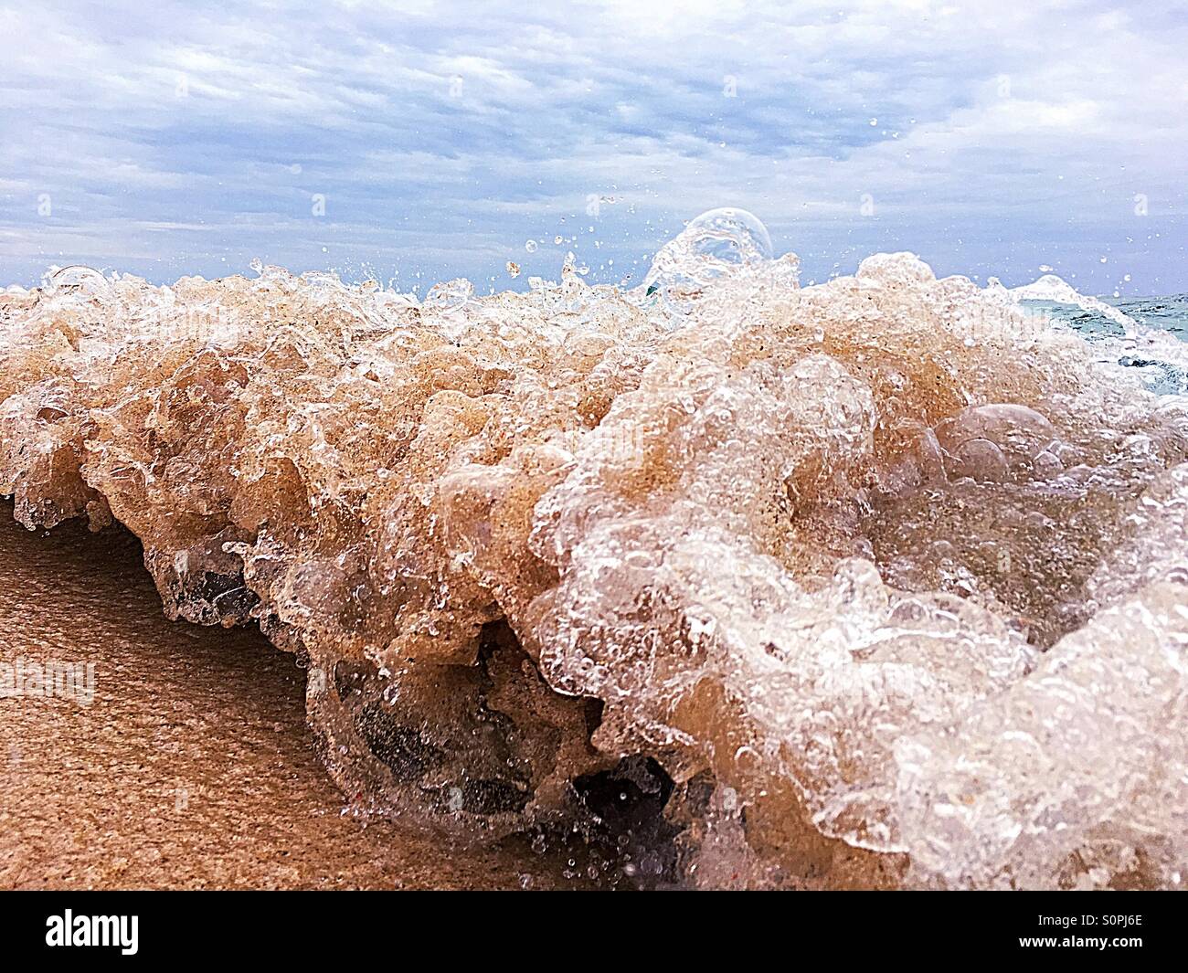 Close up small wave breaking capturing movement of the ocean - Smartphone Captured Stock Image