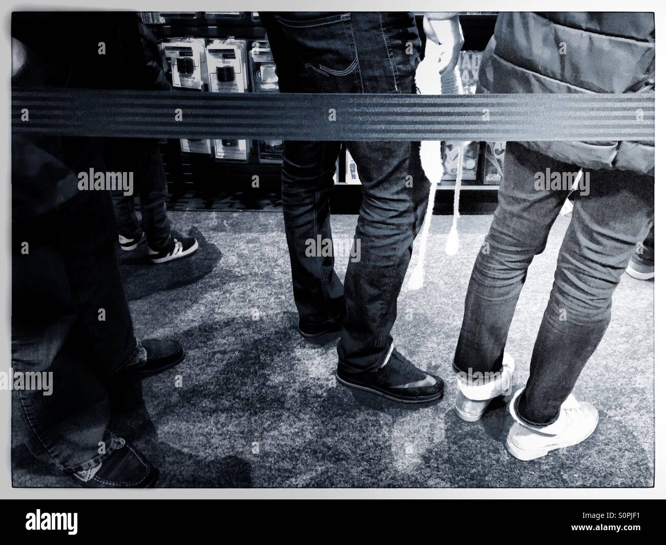 Shoppers standing in a queue behind a barrier - Smartphone Captured Stock Image