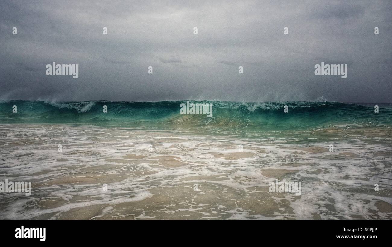 Foreboding sky as wave comes in to break onto the beach - Smartphone Captured Stock Image