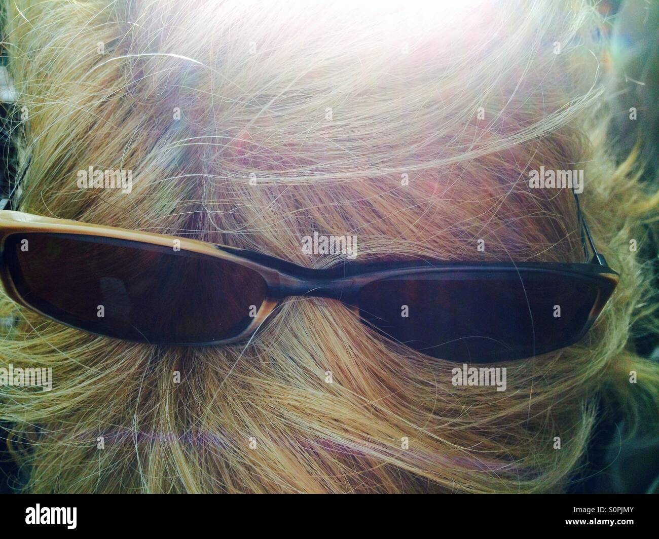 Sunglasses sitting on the top of a blonde woman's head - Smartphone Captured Stock Image