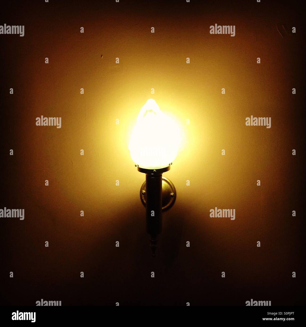 Warm golden glow of a wall light in a theatre - Smartphone Captured Stock Image