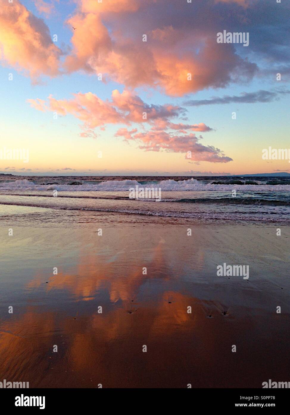 Sunset clouds reflected in wet beach sand - Smartphone Captured Stock Image