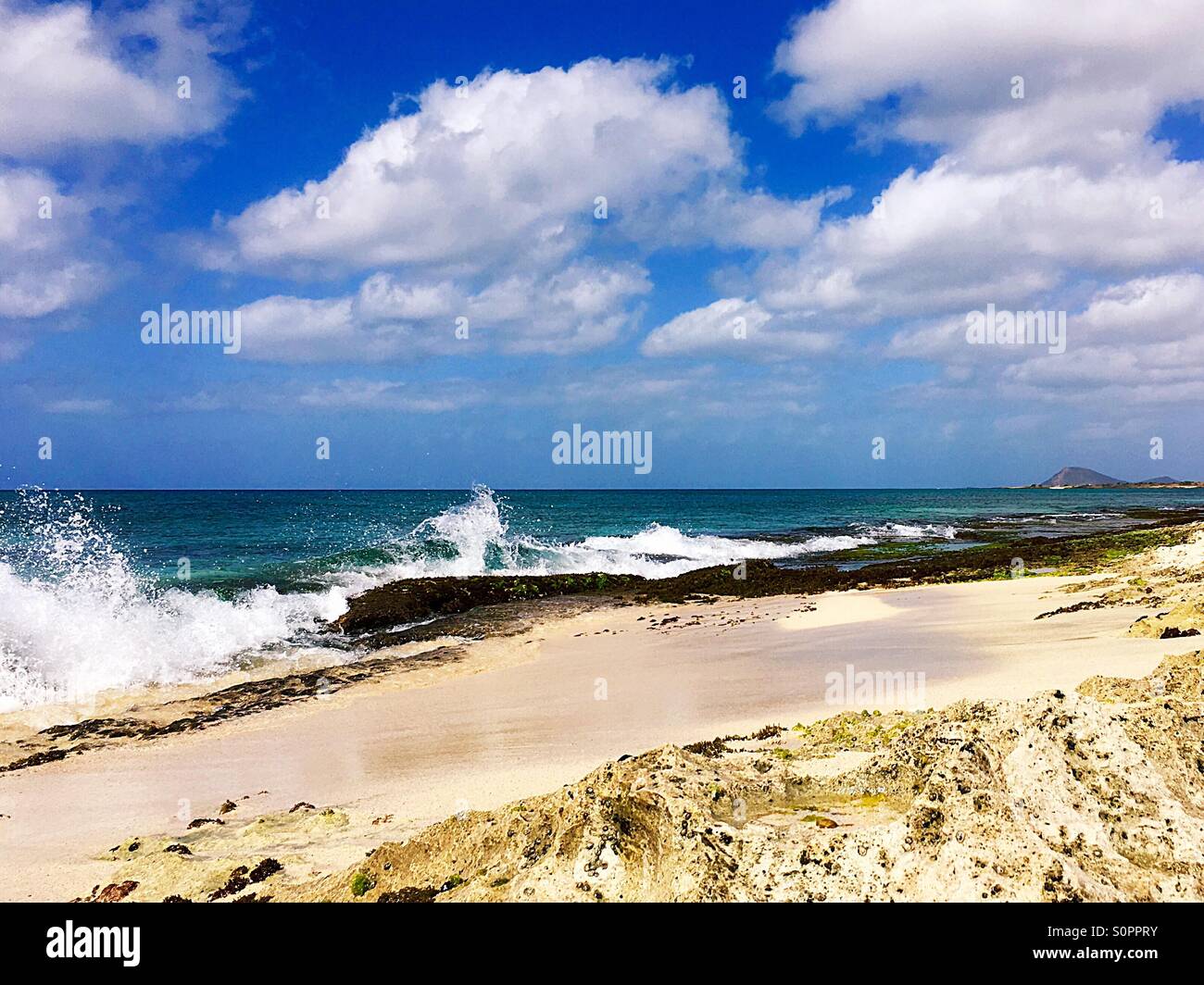 Tropical beach with waves crashing on rocks - Smartphone Captured Stock Image