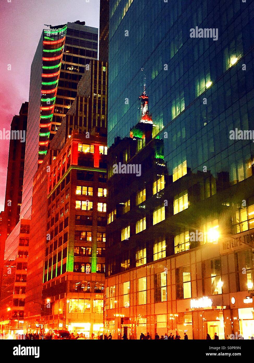 NYC's sixth Avenue is a blaze in the red and Green holiday lights and reflections of the Empire State Building - Smartphone Captured Stock Image