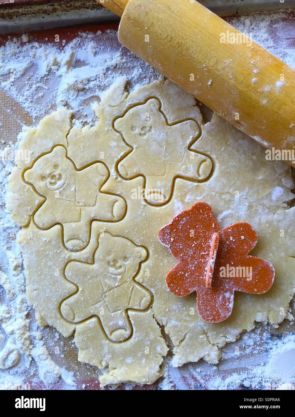 Cutting out teddy bear cookie shapes - Smartphone Captured Stock Image