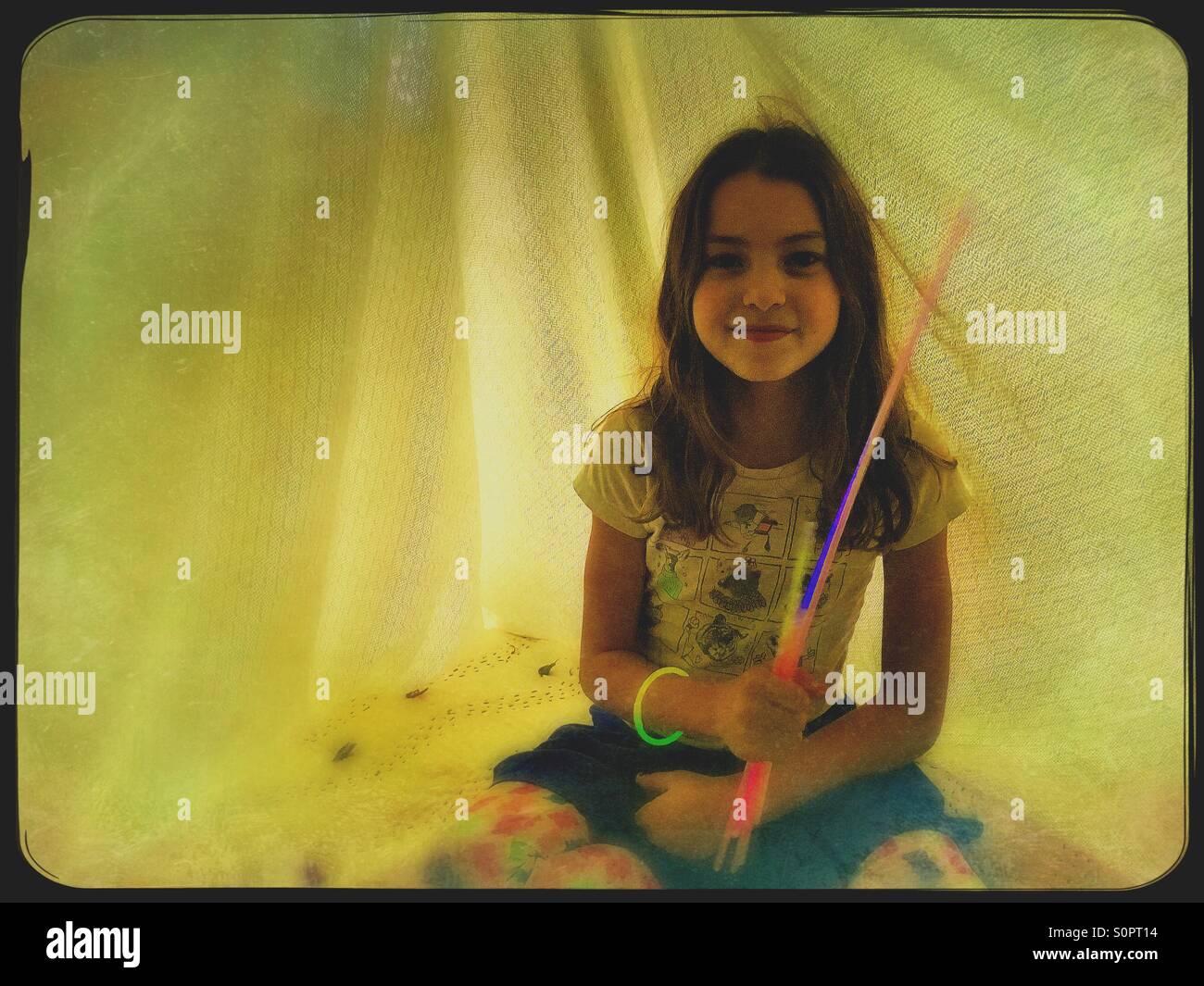 Girl in blanket fort with glow sticks - Smartphone Captured Stock Image