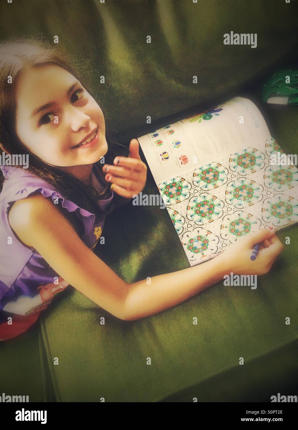 Girl coloring on couch - Smartphone Captured Stock Image