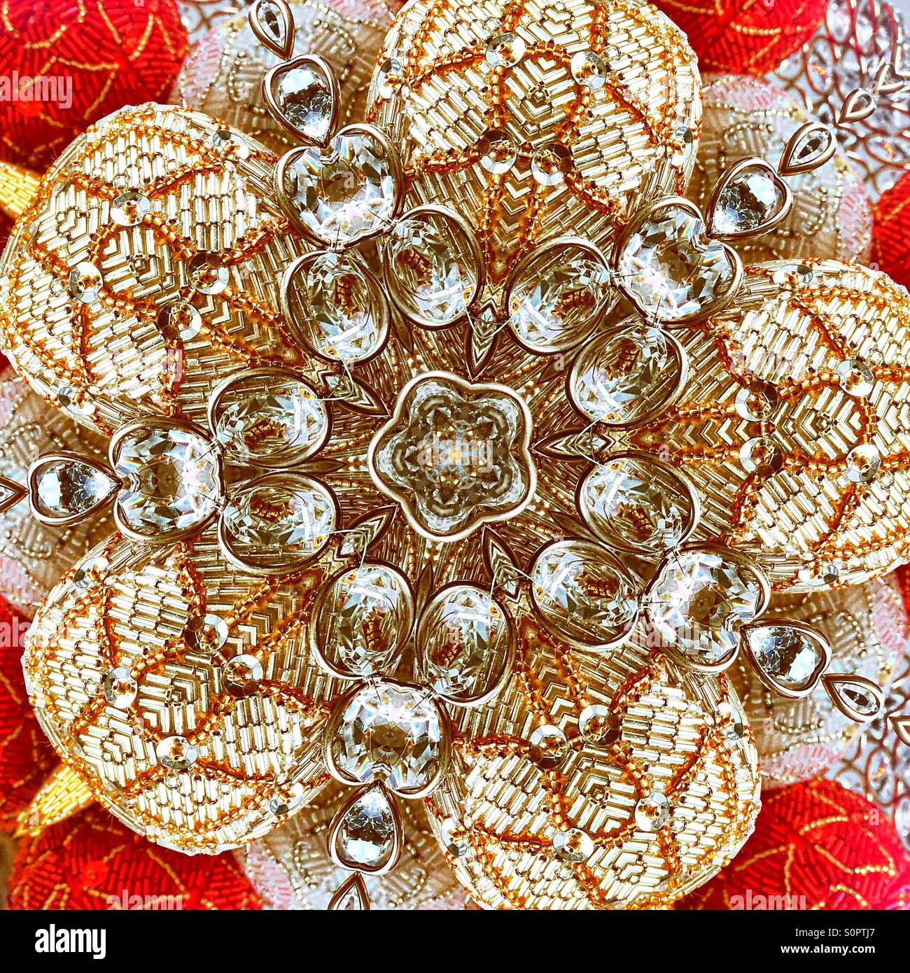 A macro view of a kaleidoscopic image of sequins and jewels in the shape of a star burst or a flower - Smartphone Captured Stock Image