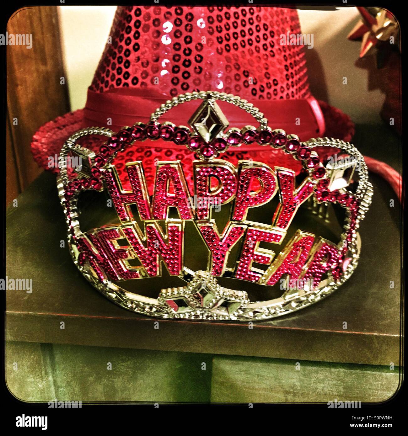 Happy new year tiara with a pink sequenced hat behind it. - Smartphone Captured Stock Image