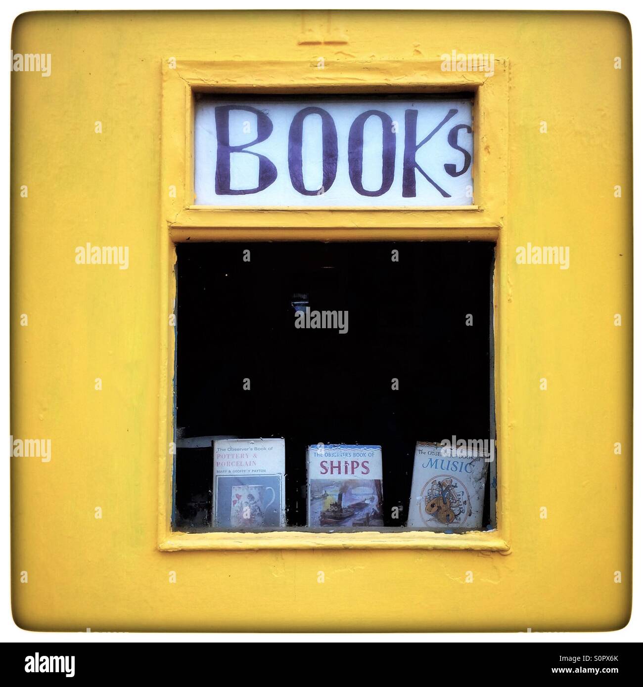Books sign in shop window with yellow wall - Smartphone Captured Stock Image