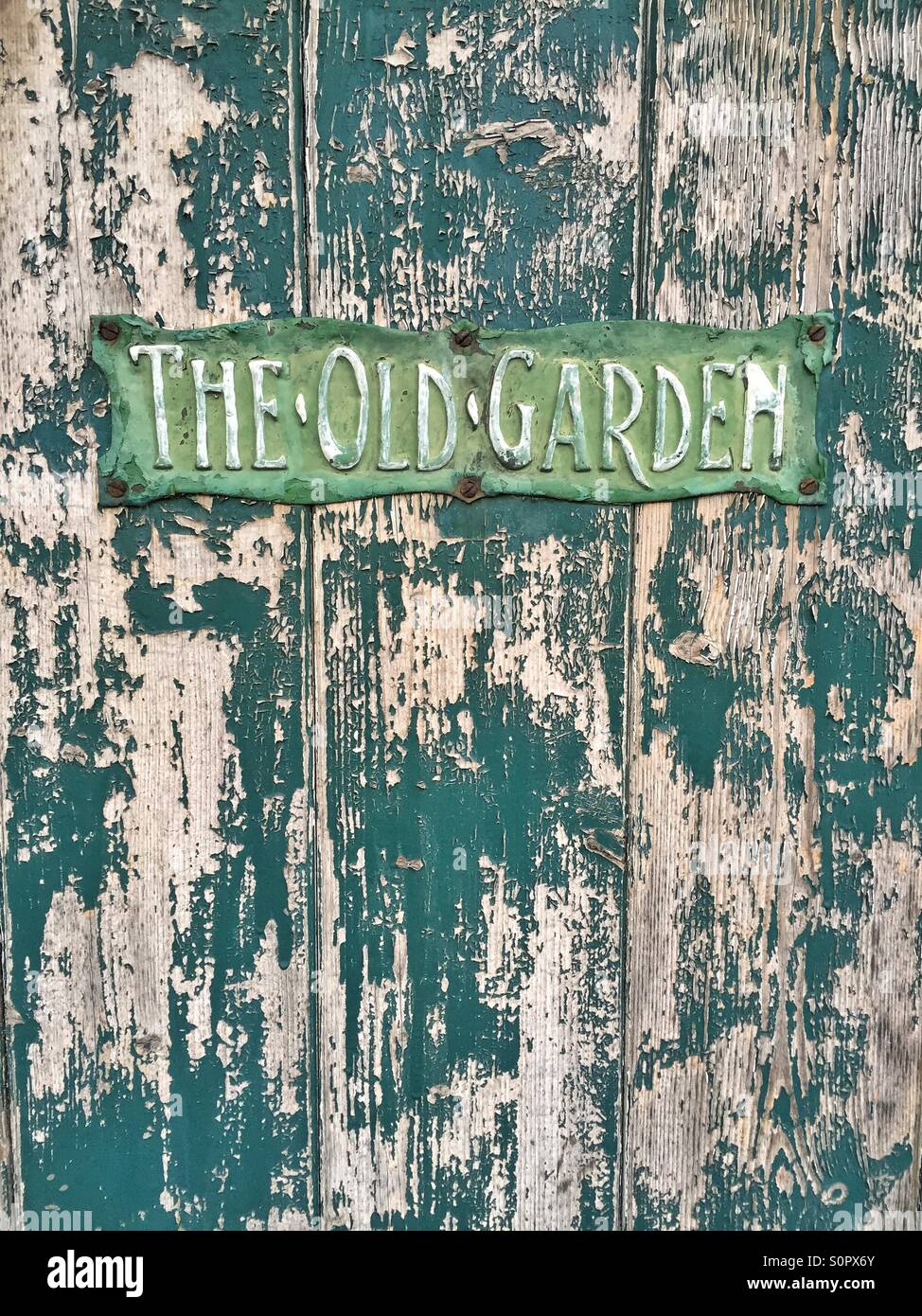 Faded sign on old door to the old garden Stock Photo