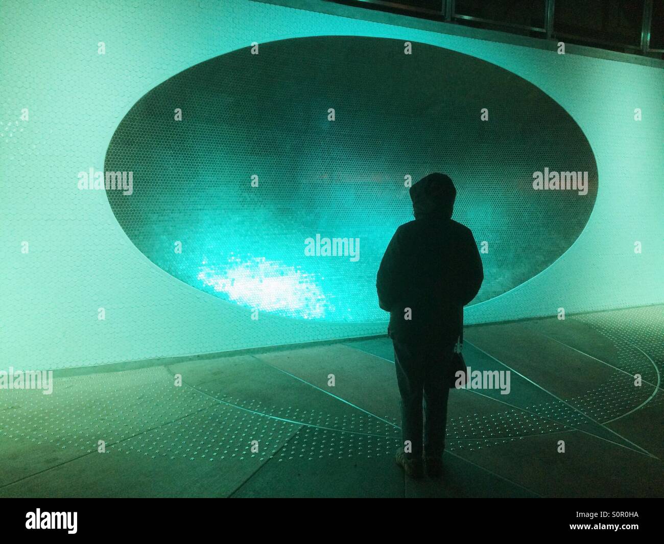 Woman and 'Sonic Dish', Tilikum Crossing Bridge, Portland, Oregon, illuminated at night - Smartphone Captured Stock Image