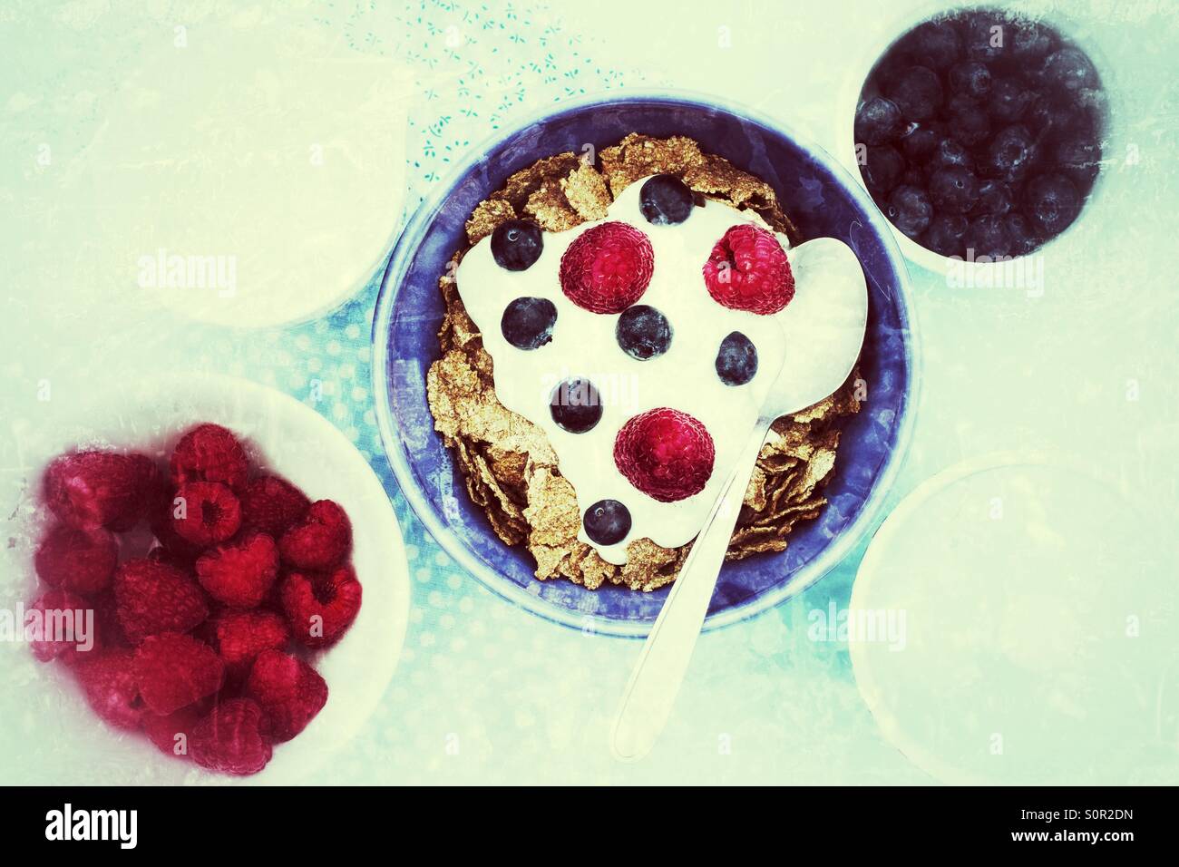 A healthy, grungy breakfast of bran flakes, raspberries, blueberries with natural yoghurt. - Smartphone Captured Stock Image