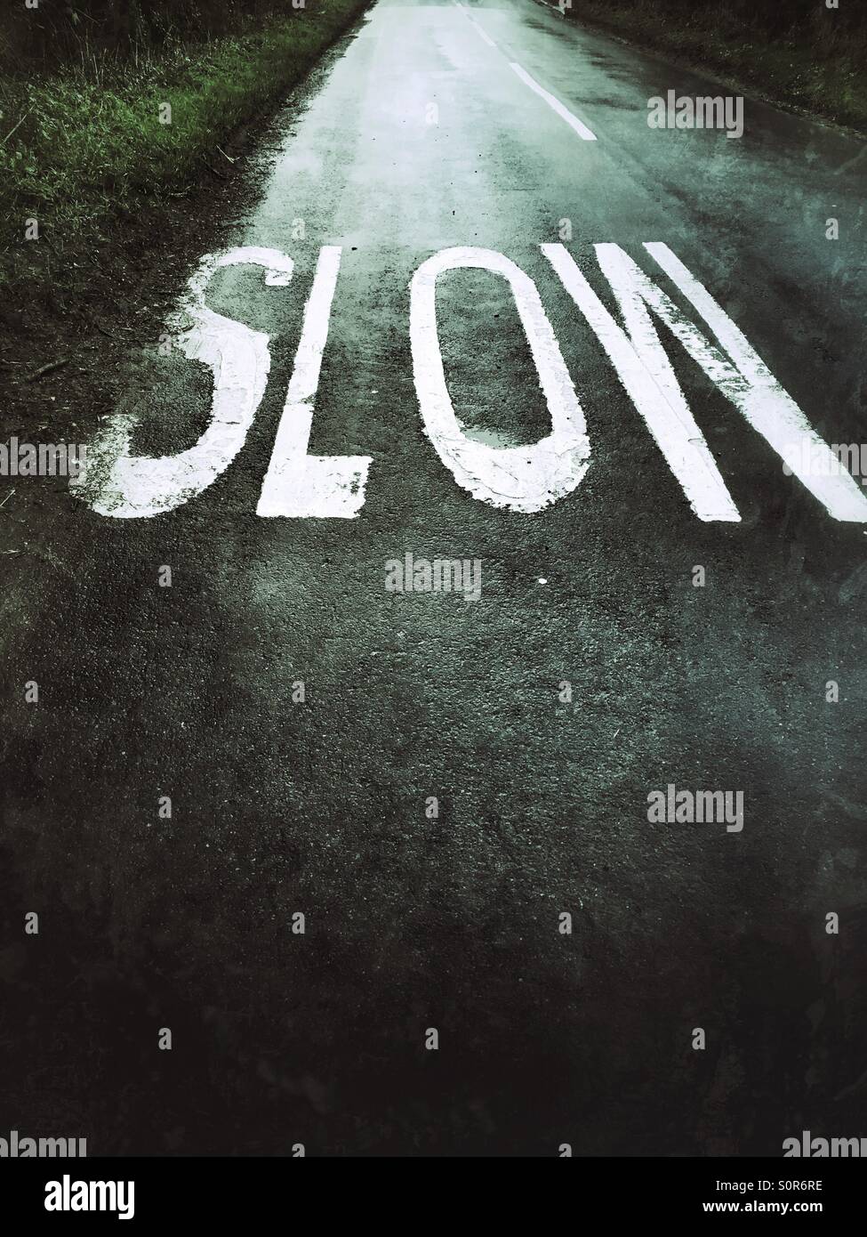 Slow sign in wet road - Smartphone Captured Stock Image