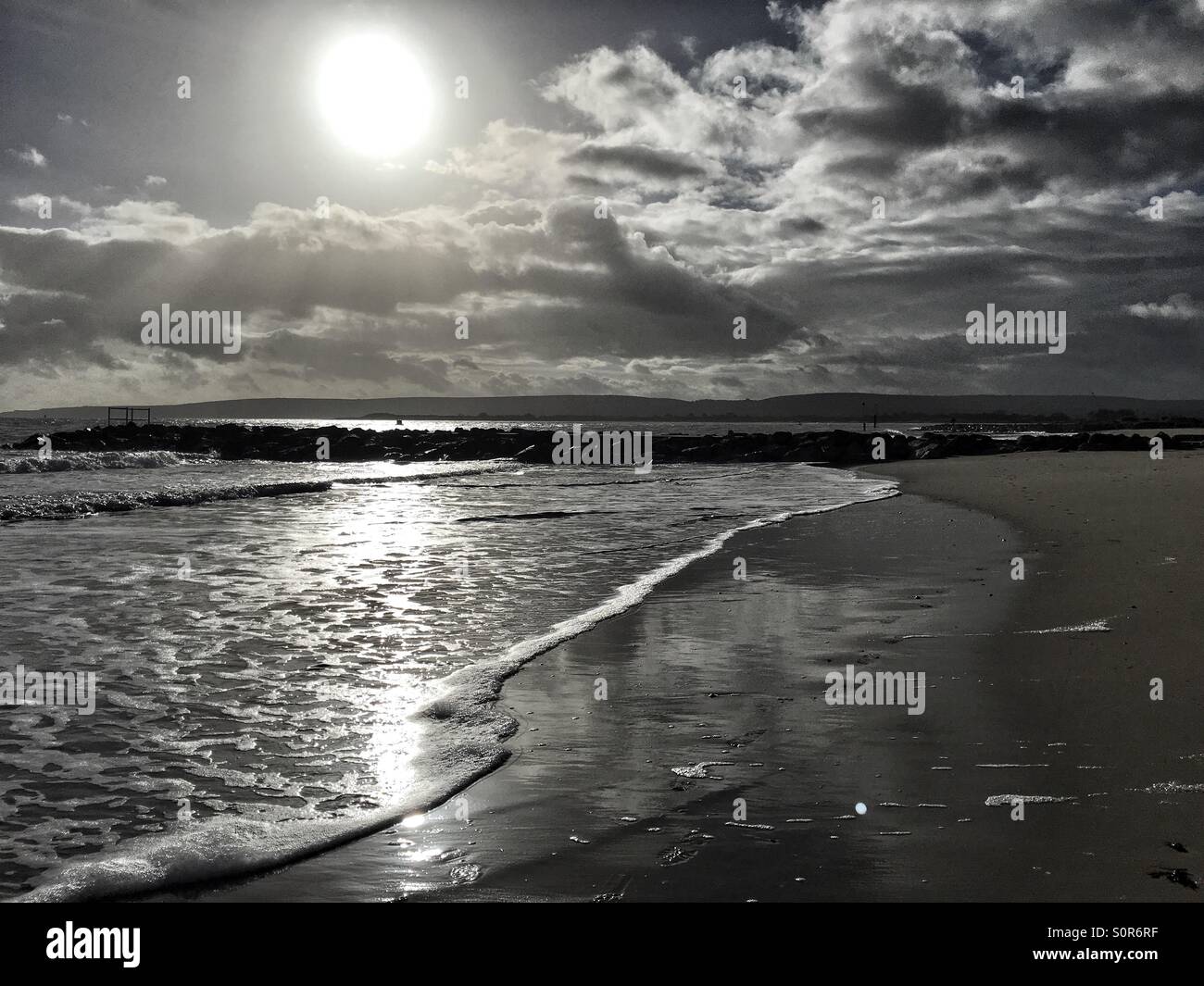 Waves lapping on a beach in low winter sunlight - Smartphone Captured Stock Image