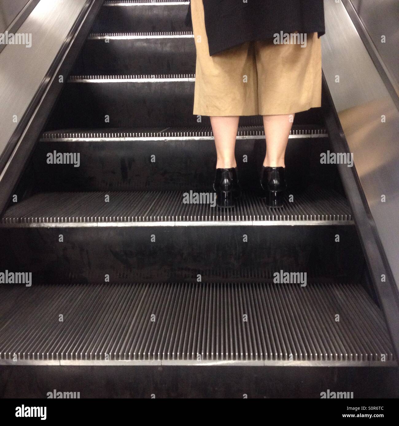 Stylish woman on escalator at London Underground station - Smartphone Captured Stock Image