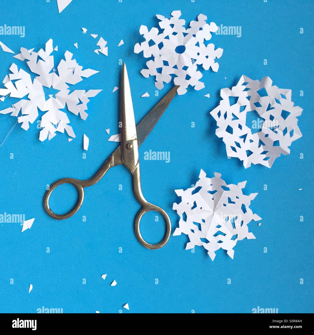 Scissors and paper snowflakes Stock Photo