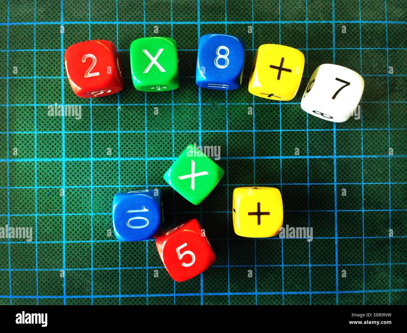 Numbers and arithmetic operators on colourful dice for practicing arithmetics Stock Photo