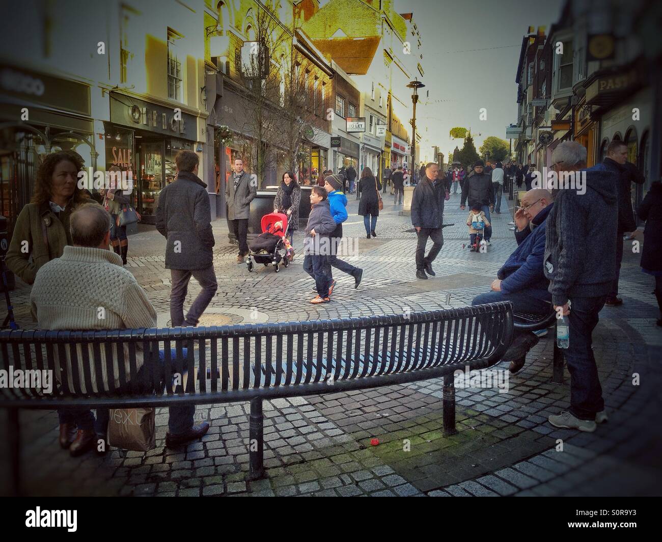 People sitting on benches in Peascod Street in Windsor, Berkshire. - Smartphone Captured Stock Image