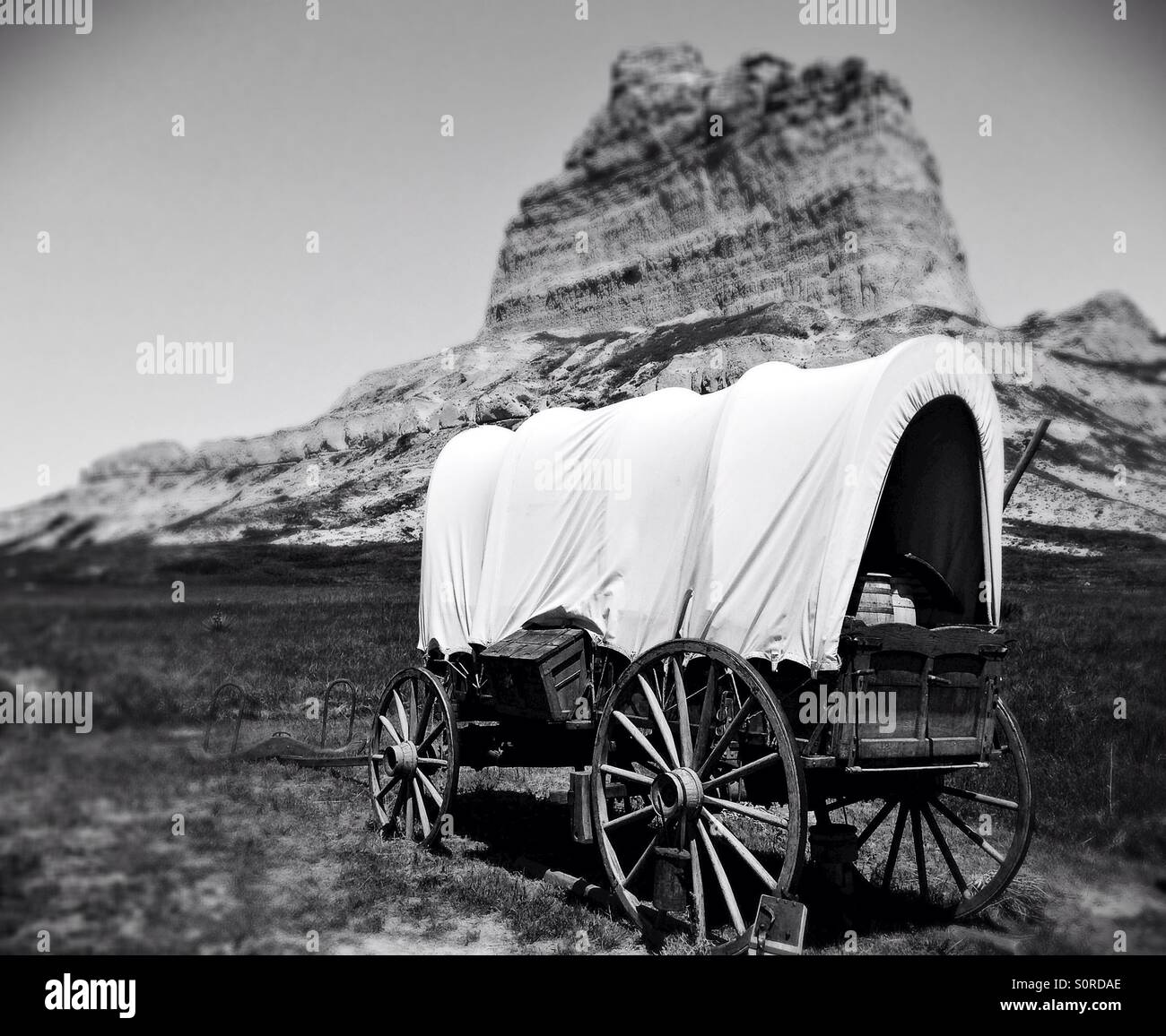 A covered wagon in front of Eagle rock at Scotts Bluff national monument in Nebraska. Stock Photo