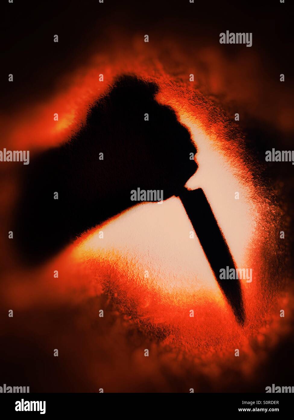 Shadow of arm holding a knife against a blood red background - Smartphone Captured Stock Image