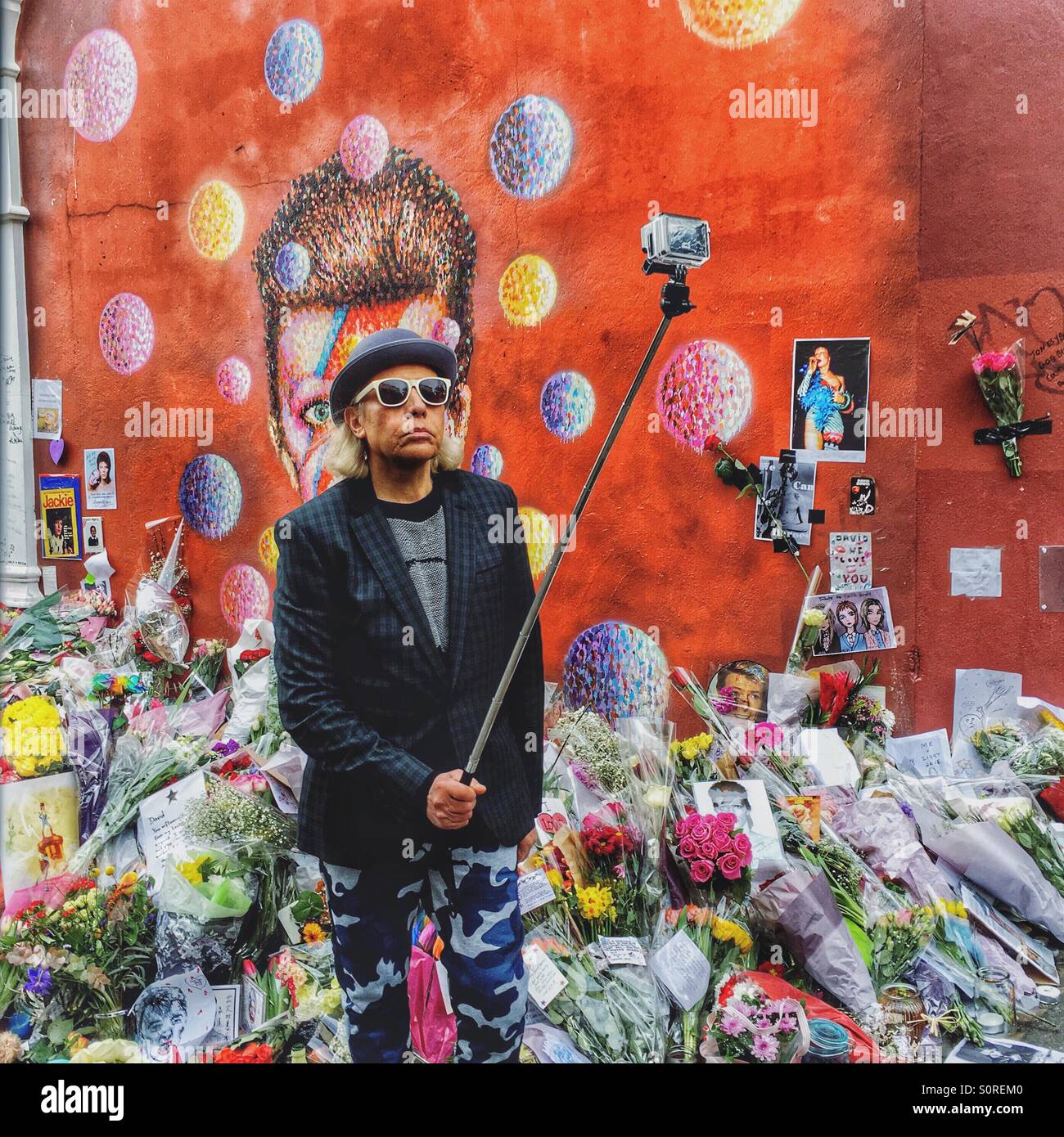 Fan taking a selfie at the David Bowie mural in Brixton London that has become a focus for tributes Stock Photo