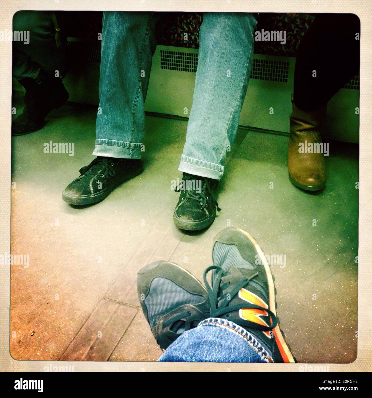 Crossed legs and shoes on a subway in Berlin Stock Photo