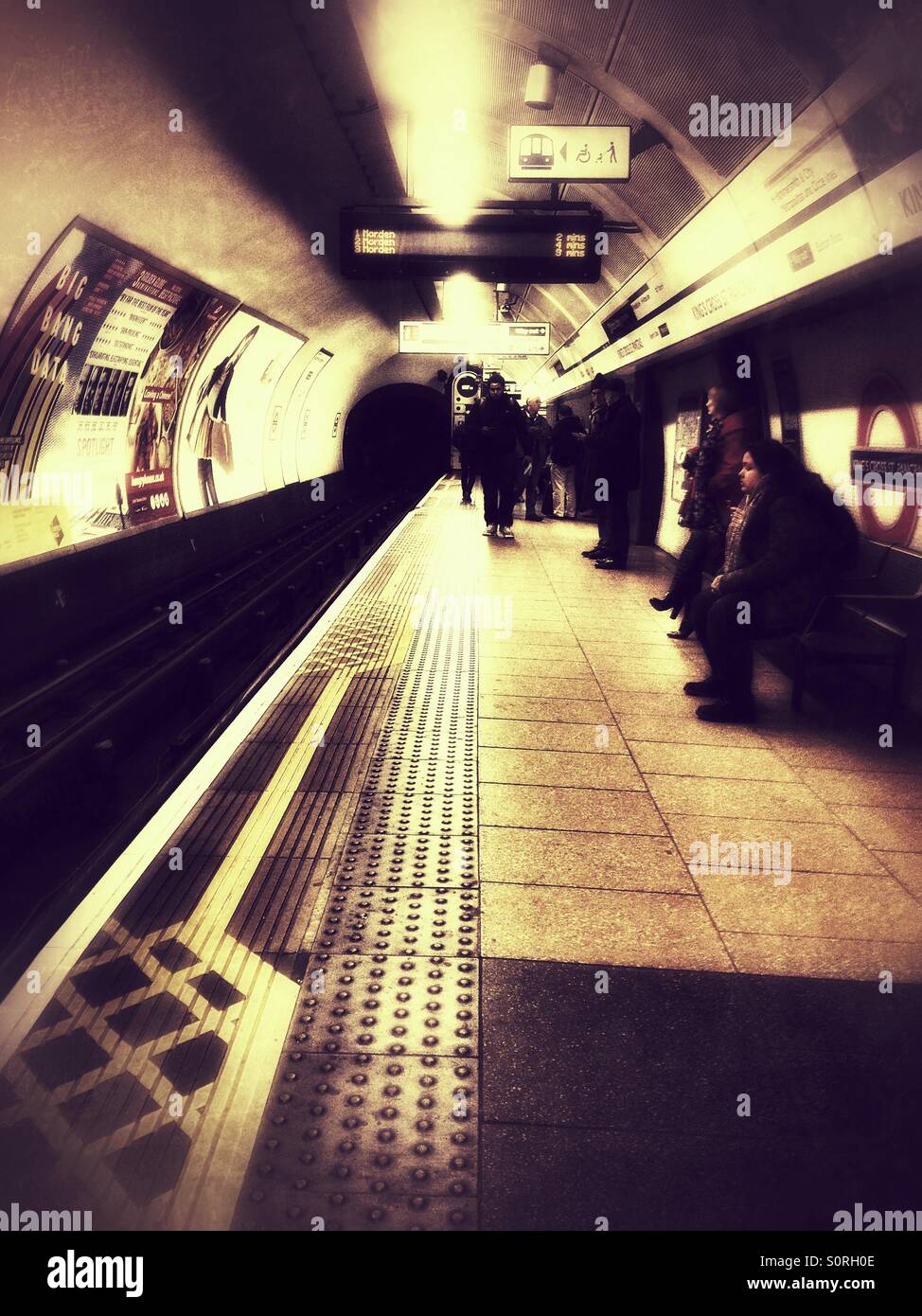Waiting for a tube train on the platform at King's Cross station on the London Underground. - Smartphone Captured Stock Image