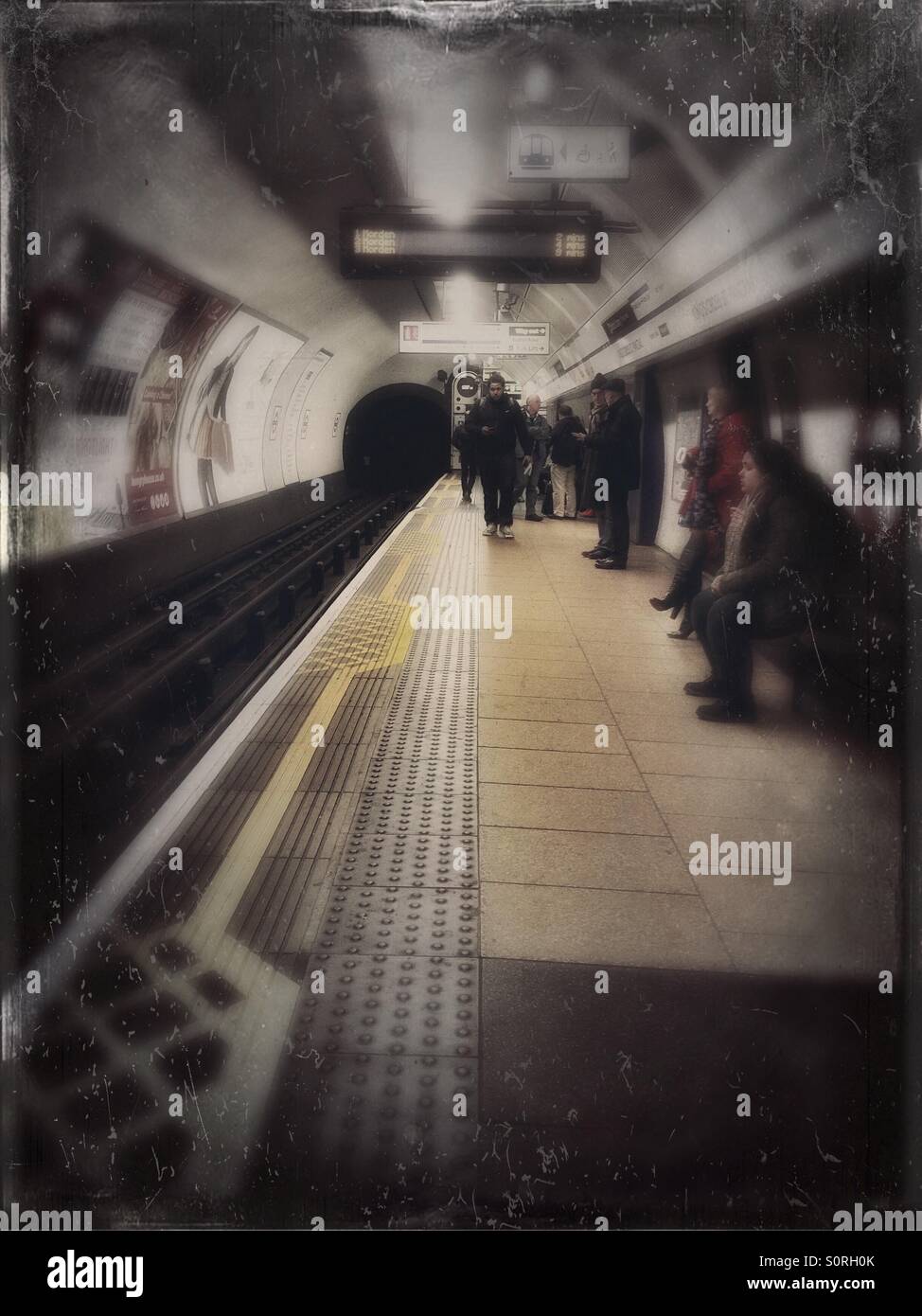 Waiting for a tube train on the platform at King's Cross station on the London Underground. - Smartphone Captured Stock Image