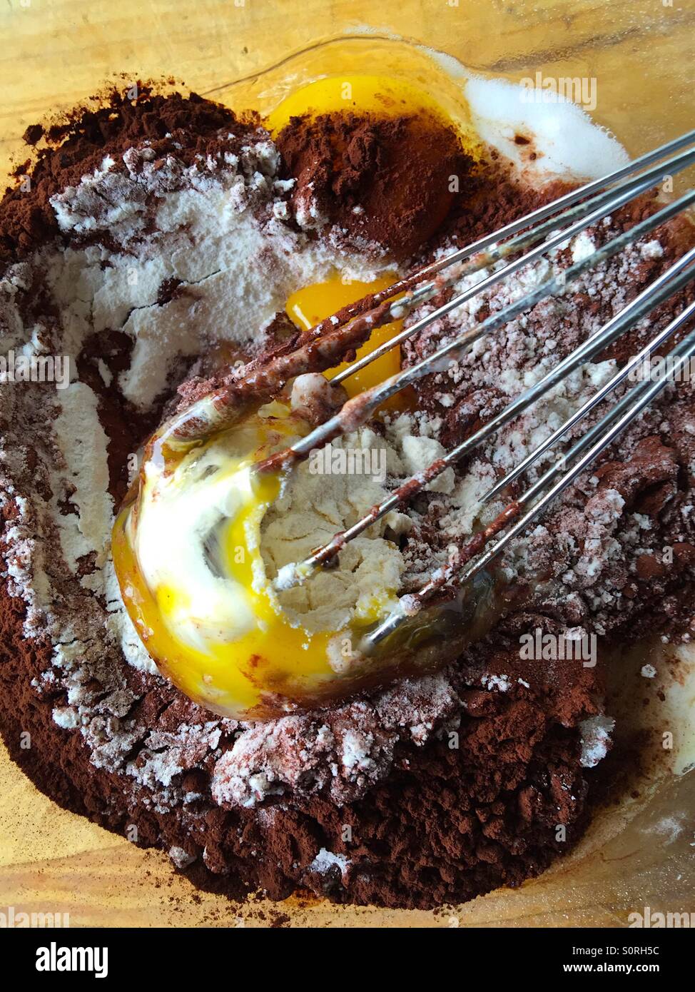 Whisking eggs into chocolate cake batter - Smartphone Captured Stock Image