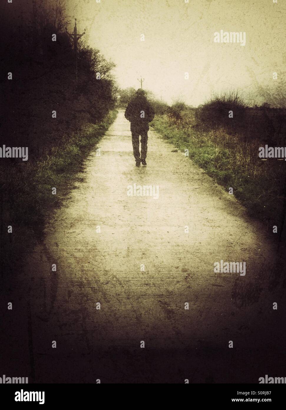 Man walking down country lane England UK United Kingdom GB Great Britain - Smartphone Captured Stock Image