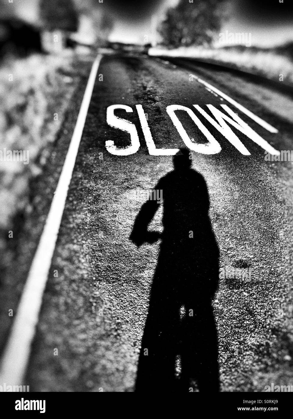 Cyclist shadow Selfie approaching a slow sign on the road in Ilkley West Yorkshire UK Stock Photo
