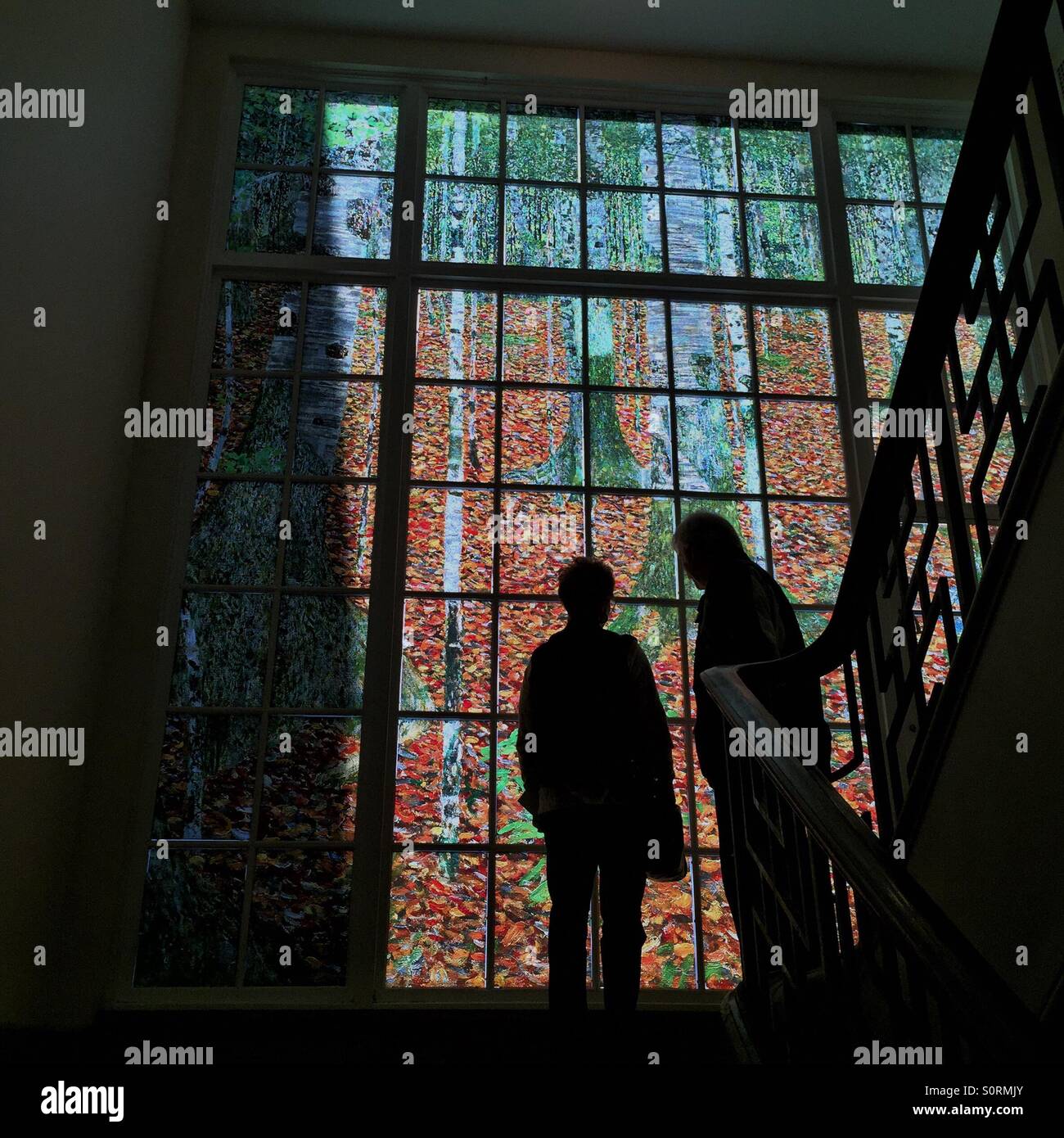 Silhouettes of two people in front of giant reproduction of Gustav Klimt landscape at Portland Art Museum - Smartphone Captured Stock Image