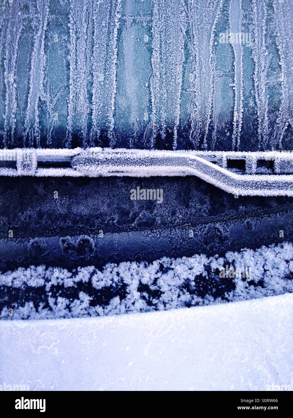 Frozen car windshield in winter and detail of windscreen wiper Stock Photo